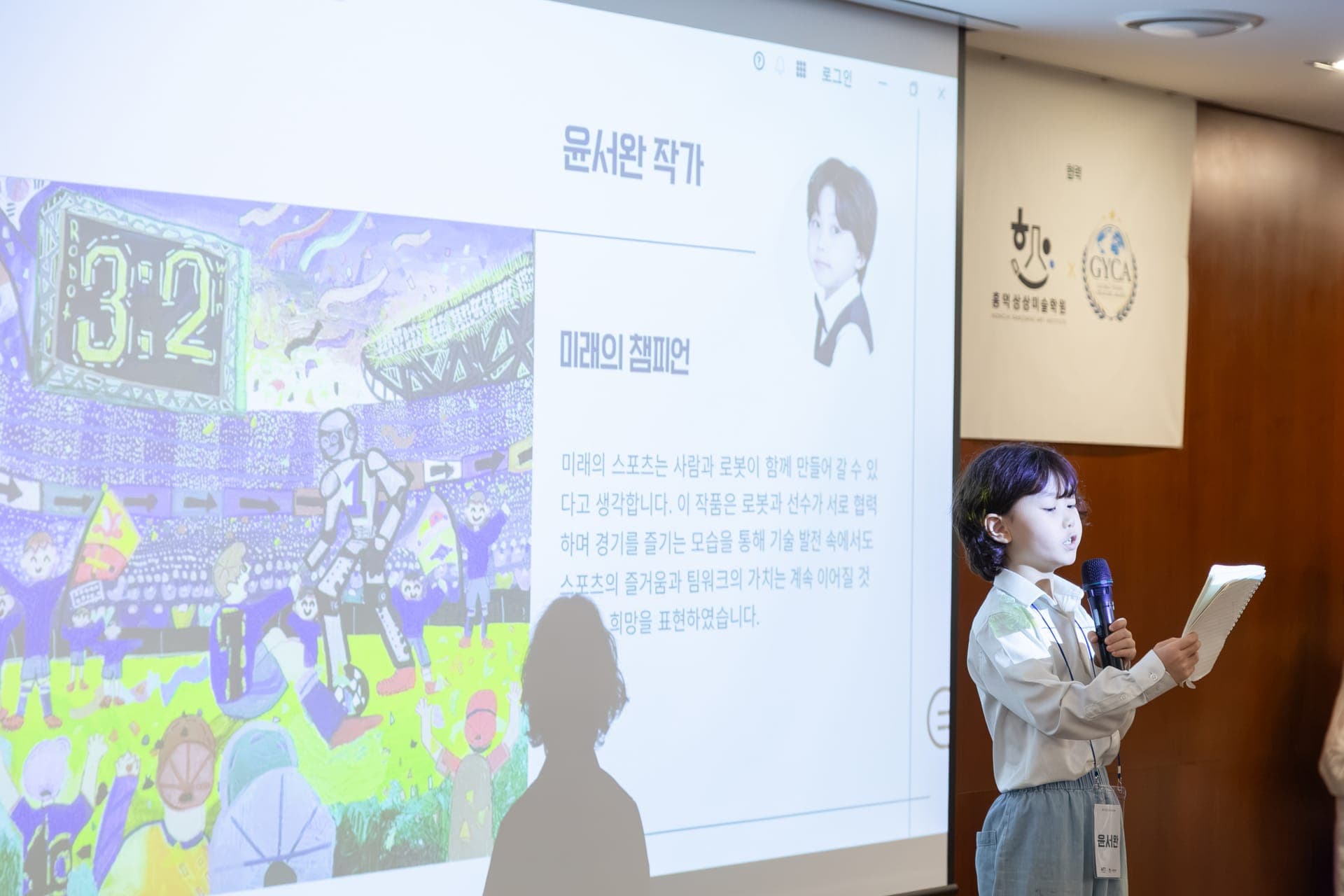 A young artist presenting their artwork to the audience